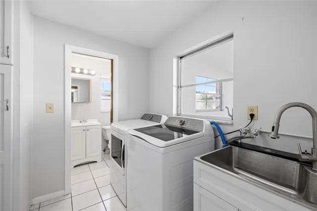 a kitchen that has a sink and a stove with wooden floor