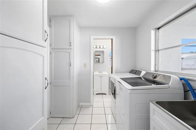 a kitchen that has a sink a refrigerator and cabinets