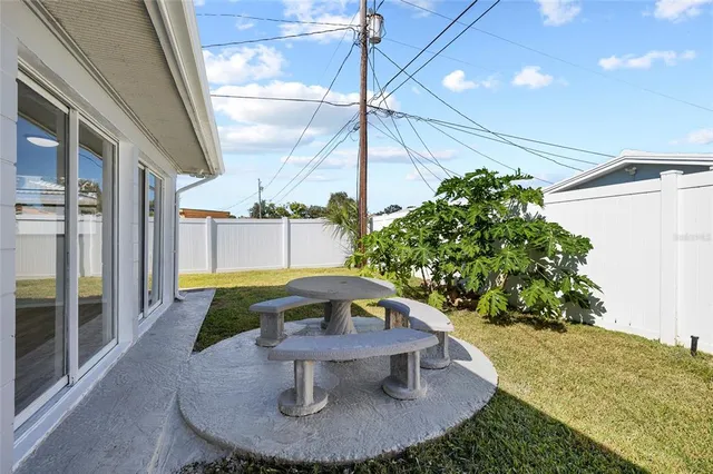 a view of a porch with a table and chairs potted plants