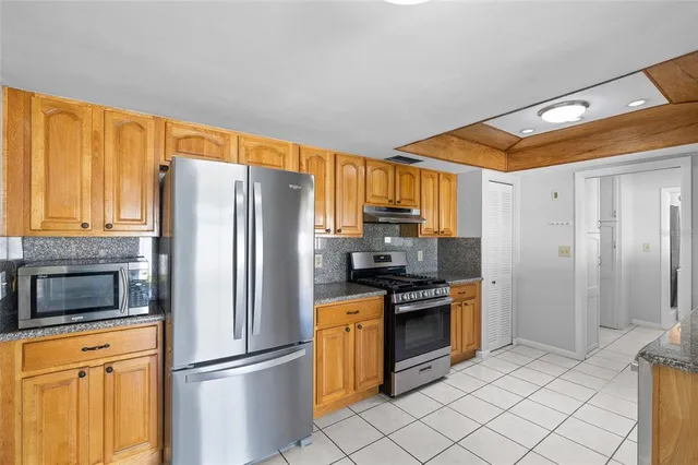 a kitchen with stainless steel appliances a refrigerator and a stove top oven