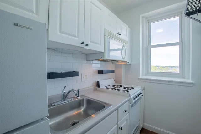 a kitchen with a sink cabinets and window