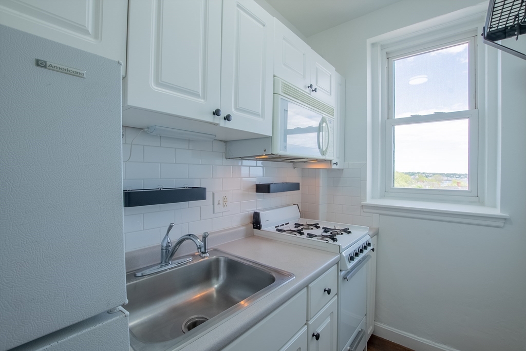 285 Lynn Shore Drive, Unit 710 Lynn, MA 01902 - Photo 5 of 26 a kitchen with a sink cabinets and window