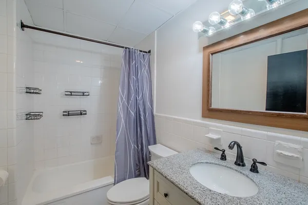 a bathroom with a granite countertop sink toilet and shower