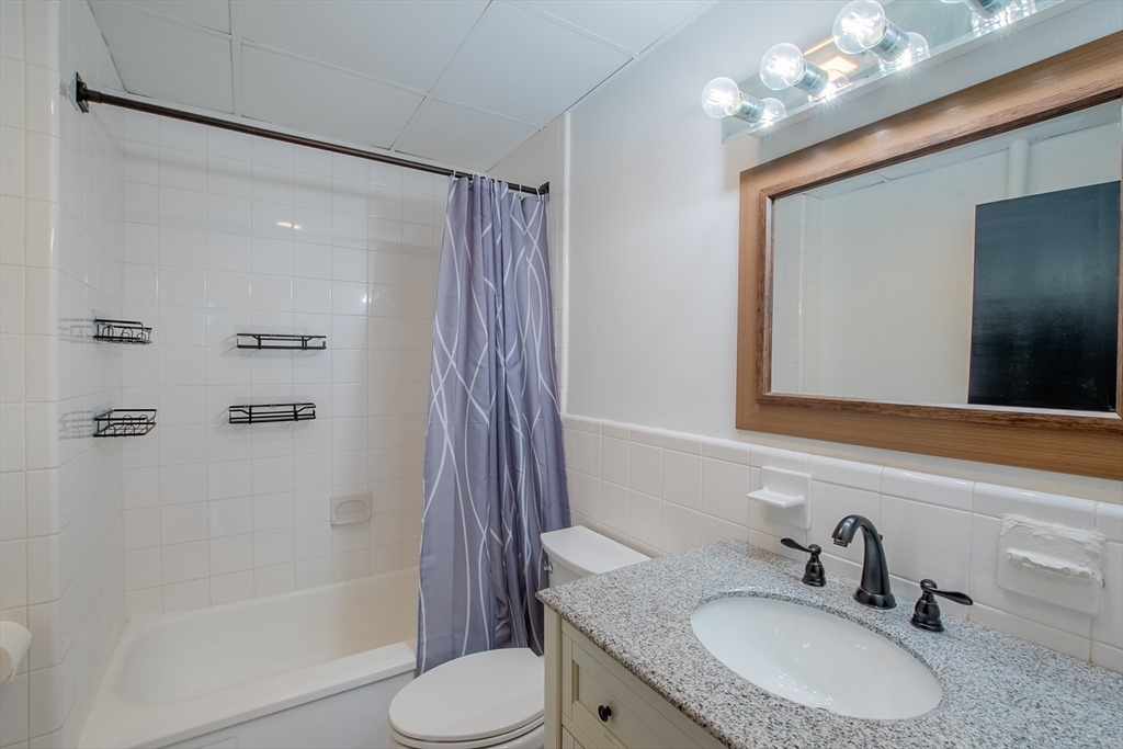 285 Lynn Shore Drive, Unit 710 Lynn, MA 01902 - Photo 6 of 26 a bathroom with a granite countertop sink toilet and shower
