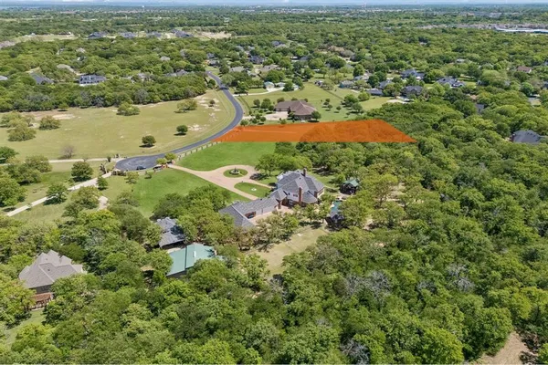 an aerial view of residential houses with outdoor space and trees