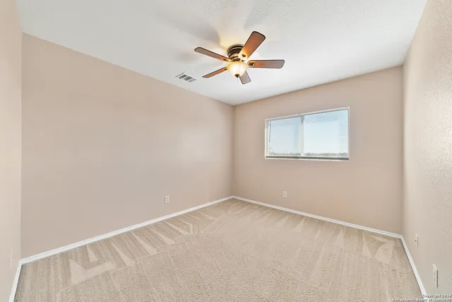 a view of a big room with wooden floor and windows