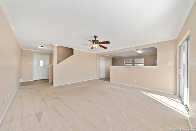 a view of a livingroom with a ceiling fan and window