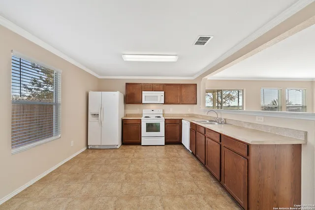 a large kitchen with stainless steel appliances granite countertop a large counter top a stove a sink and a refrigerator