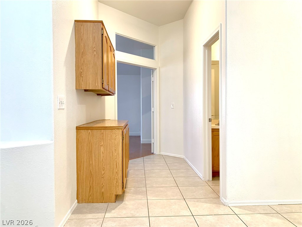 3821 Bombastic Court Las Vegas, NV 89147 - Photo 12 of 36 This interior hallway features functional cabinetry and durable tile flooring, creating a practical space.