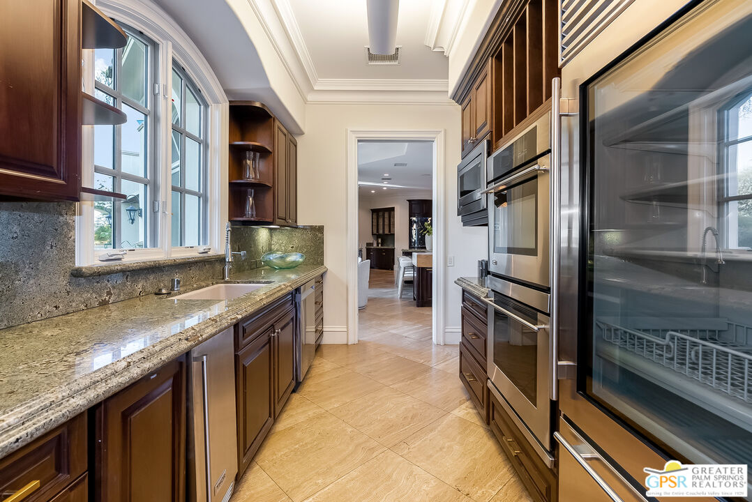 1 St Petersburg Court Rancho Mirage, CA 92270 - Photo 27 of 73 a kitchen with granite countertop a sink and stove