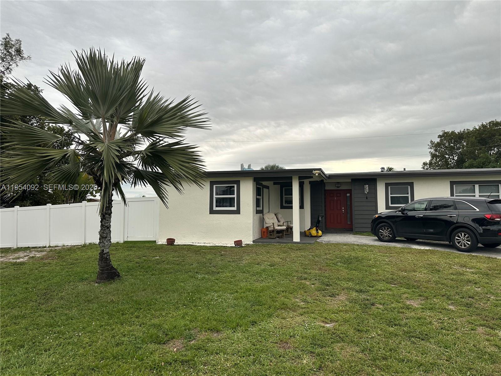 a view of a house with a yard and sitting area