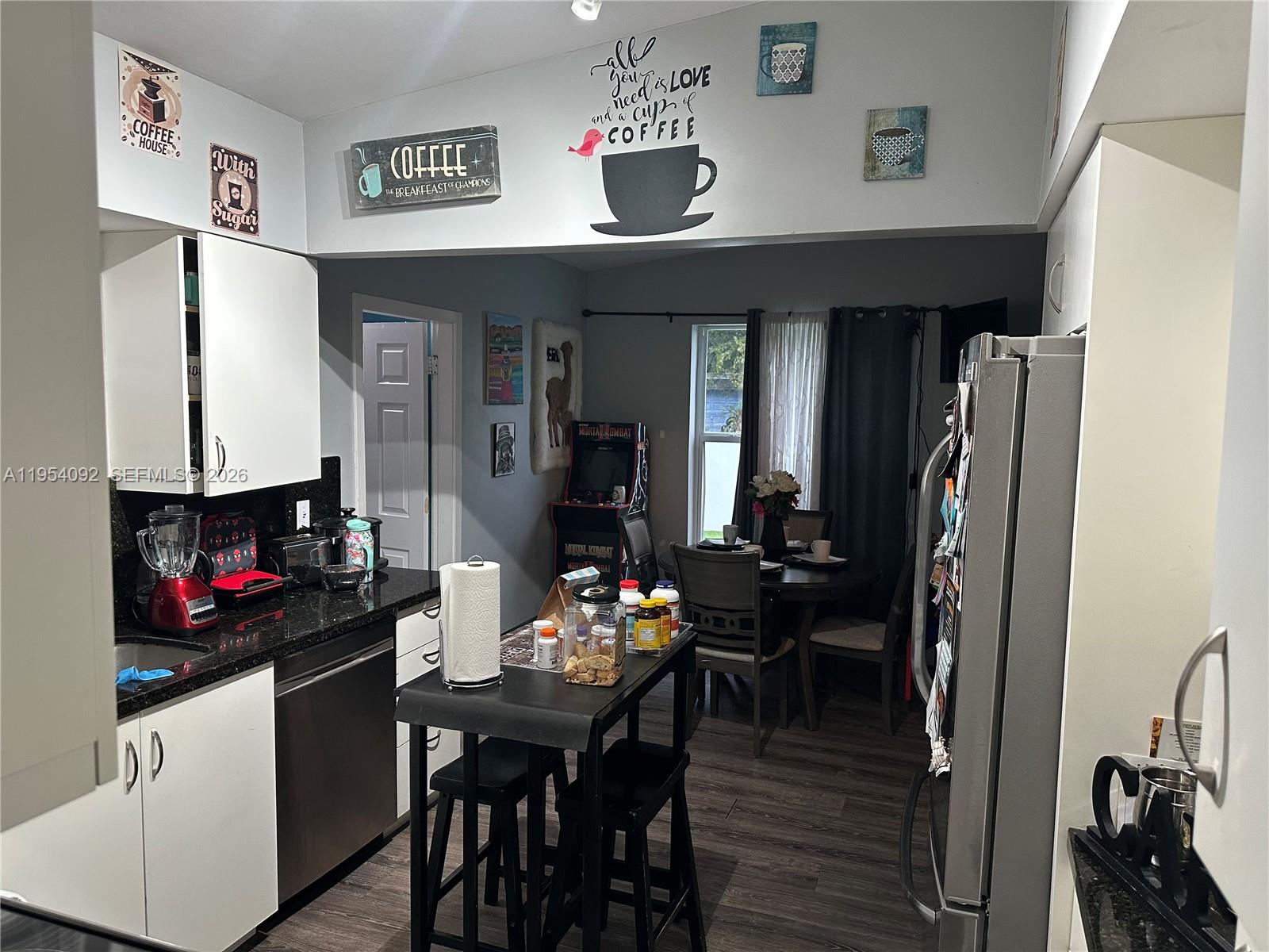 5700 Southwest 54th Terrace Davie, FL 33314 - Photo 11 of 49 a kitchen with stainless steel appliances a dining table and chairs