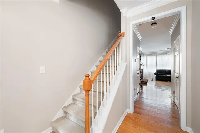 a view of a hallway with wooden floor and staircase