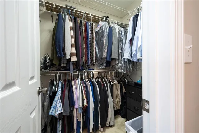 a view of walk in closet with clothes
