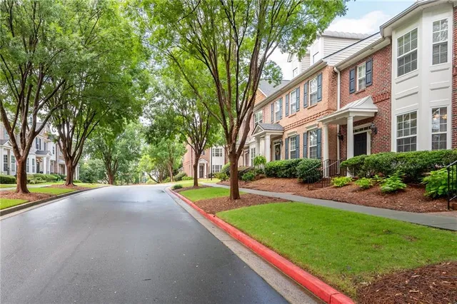 a front view of a house with a yard and trees
