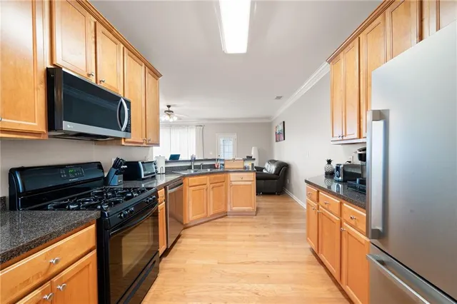 a kitchen with stainless steel appliances kitchen island granite countertop a stove a sink and a microwave
