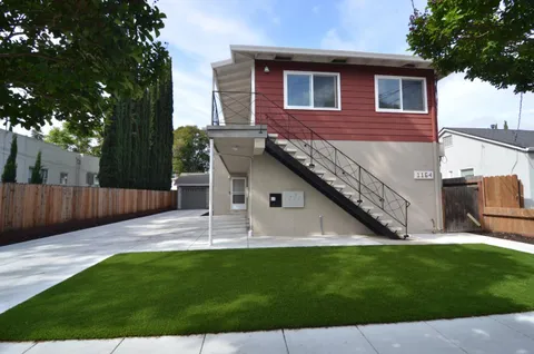 a backyard of a house with table and chairs