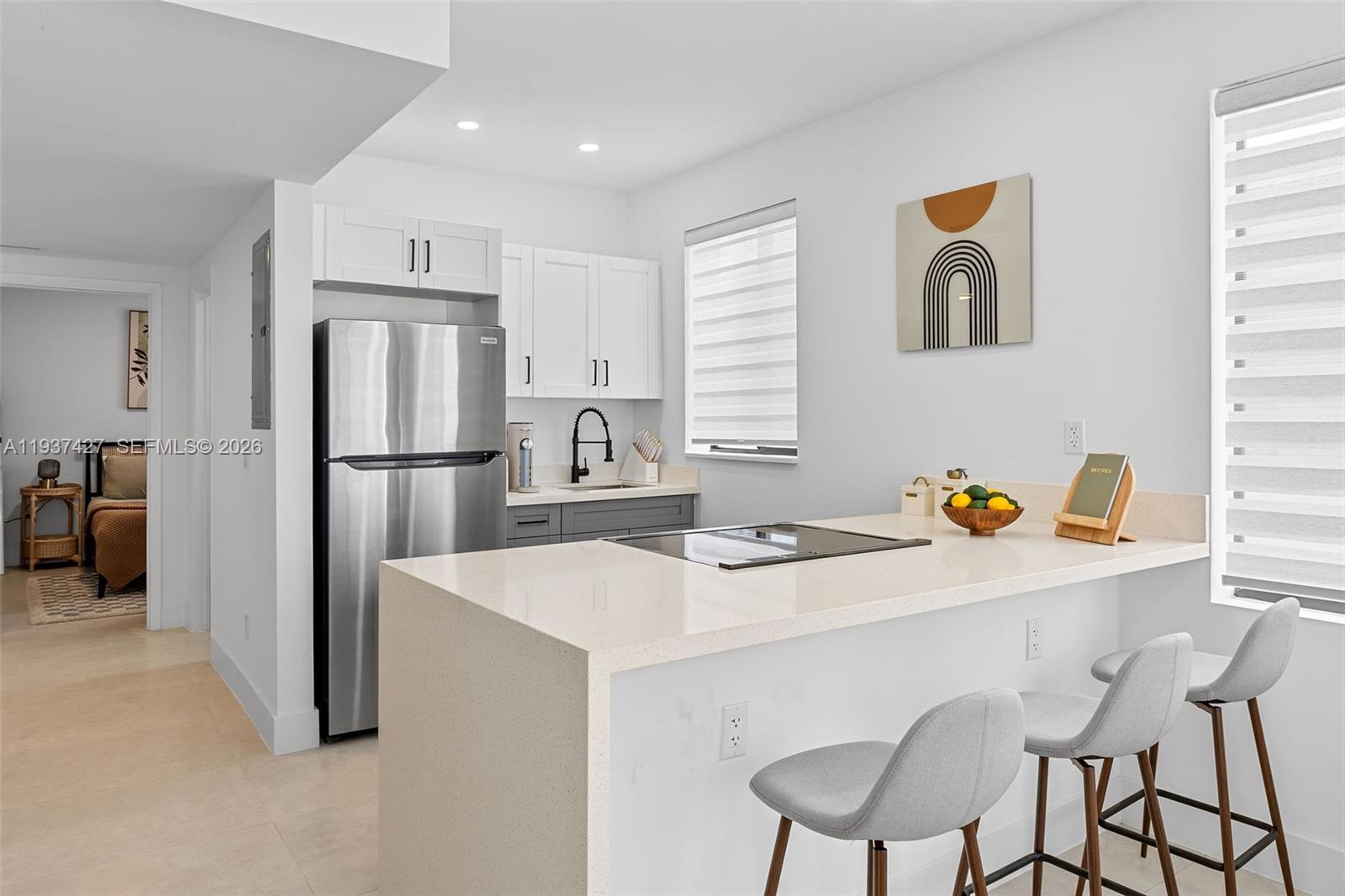 1144 Southwest 4th Street, Unit 8 Miami, FL 33130 - Photo 4 of 16 a kitchen with a refrigerator a stove a sink cabinets and a dining table