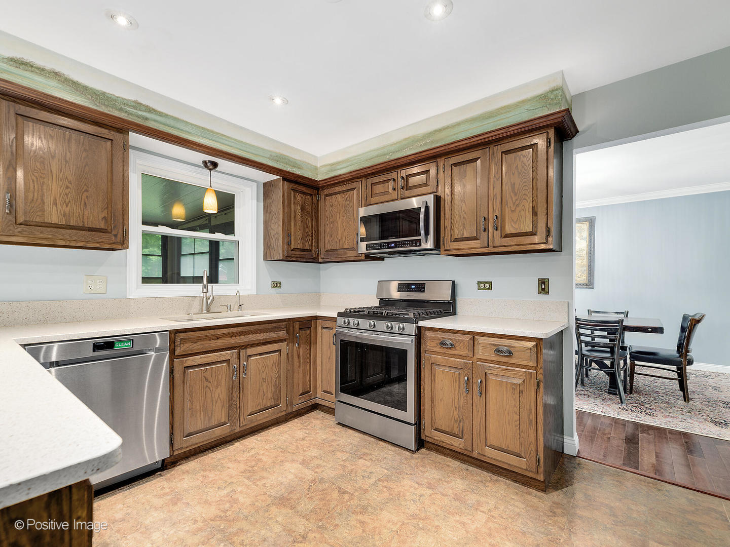 N412 Indian Knoll Road West Chicago, IL 60185 - Photo 12 of 25 a kitchen with stainless steel appliances granite countertop a stove top oven a sink dishwasher a dining table and chairs with wooden floor