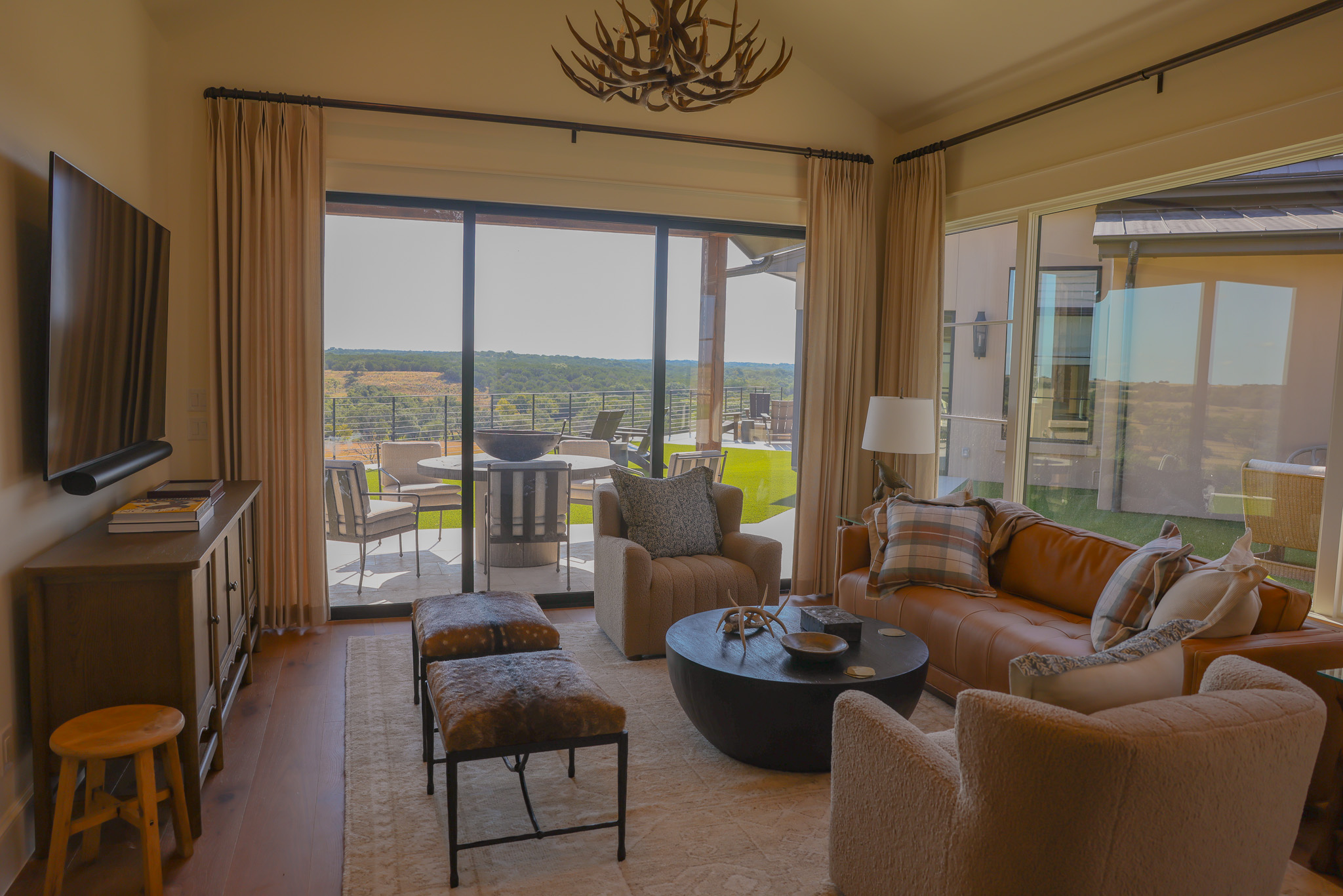 920 Ryan Road Bertram, TX 78605 - Photo 34 of 40 Floor-to-ceiling glass doors open to outdoor living spaces with scenic green views.