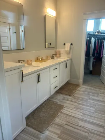 a spacious bathroom with a double vanity sink and a mirror