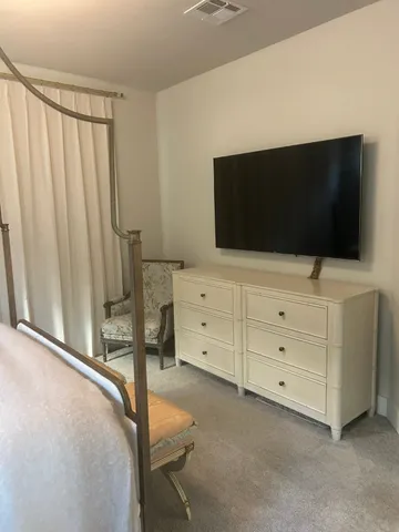 a bedroom with a bed and flat screen tv