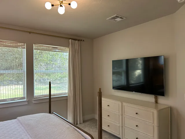 a living room with flat screen tv and floor to ceiling window