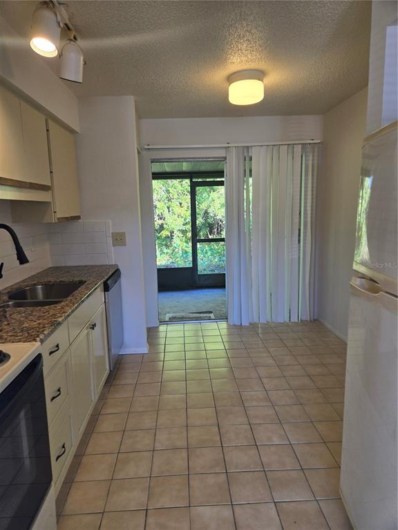 1313 54th Avenue East, Unit 1313 Bradenton, FL 34203 - Photo 8 of 17 a kitchen with a cabinets appliances and a window
