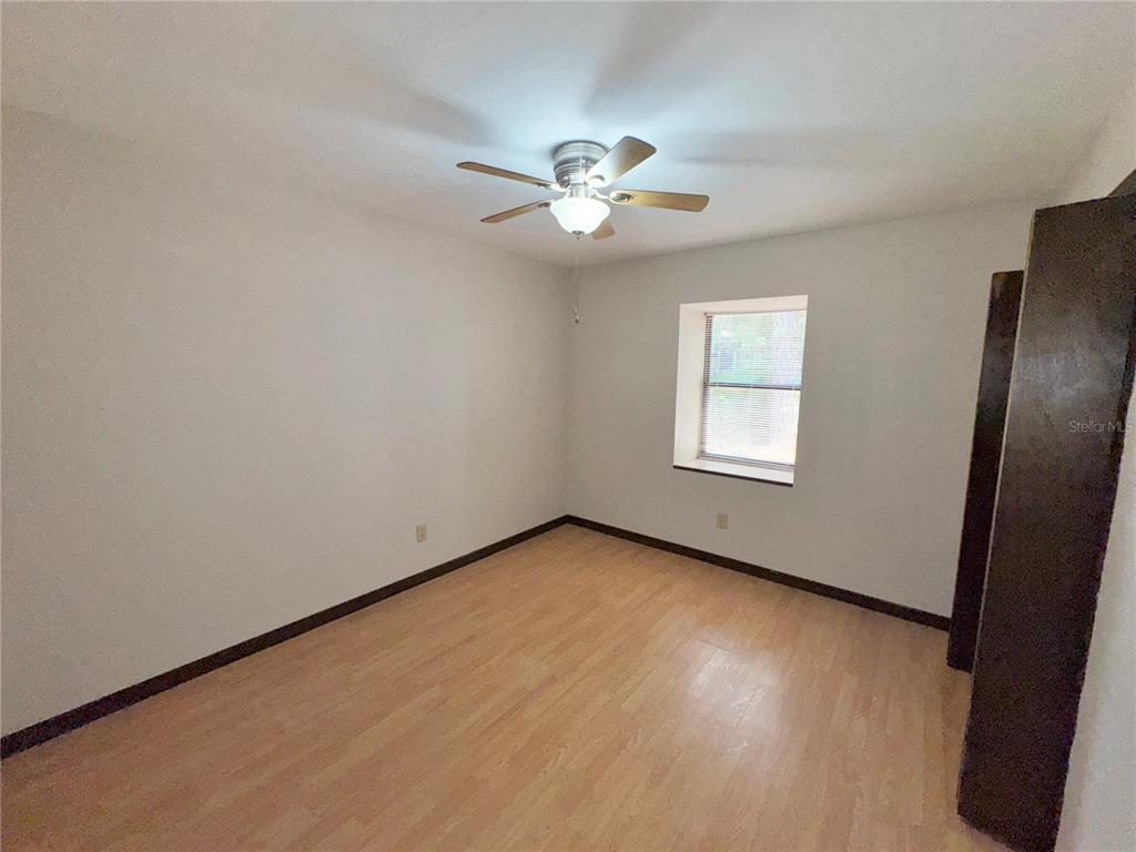 4300 Northeast 17th Terrace Gainesville, FL 32609 - Photo 16 of 21 an empty room with wooden floor fan and windows