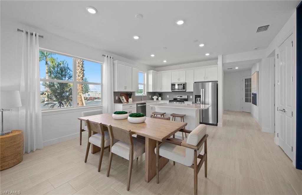 12669 Pyrite Court Alva, FL 33920 - Photo 7 of 13 a kitchen with a dining table chairs and refrigerator