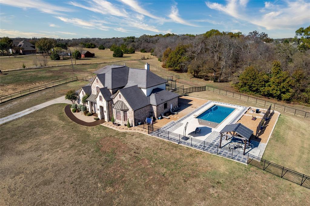 an aerial view of a house with garden space and mountains