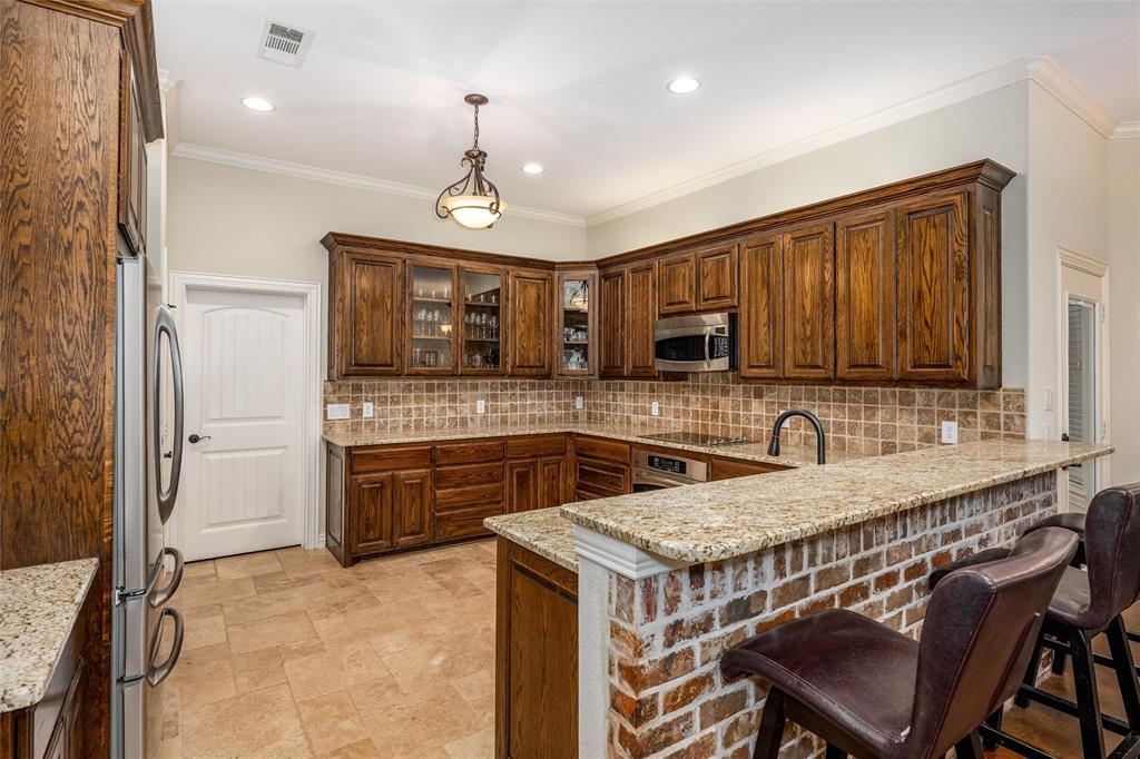 5033 Brook Lane Anna, TX 75409 - Photo 9 of 35 a kitchen with stainless steel appliances granite countertop a sink a stove a refrigerator cabinets and chairs