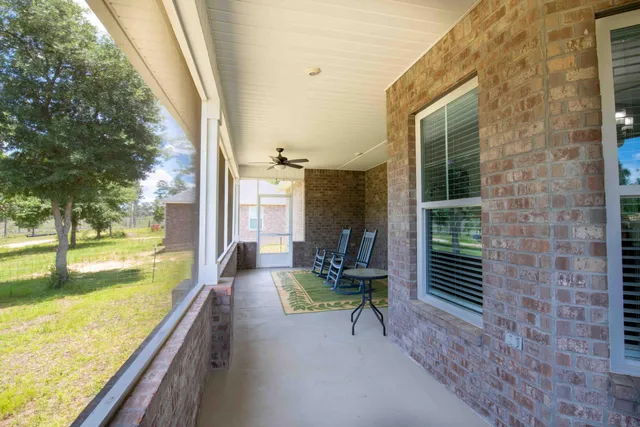 a view of a porch with furniture and a yard