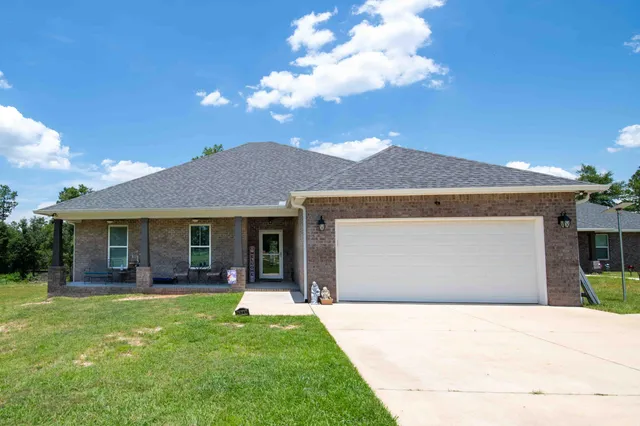 a front view of a house with a garden and yard