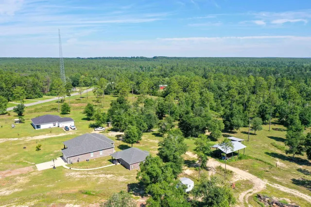 an aerial view of a house with a yard and swimming pool