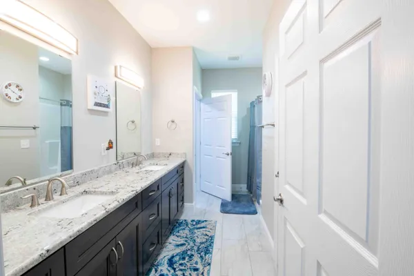a bathroom with a granite countertop double vanity sink mirror and double