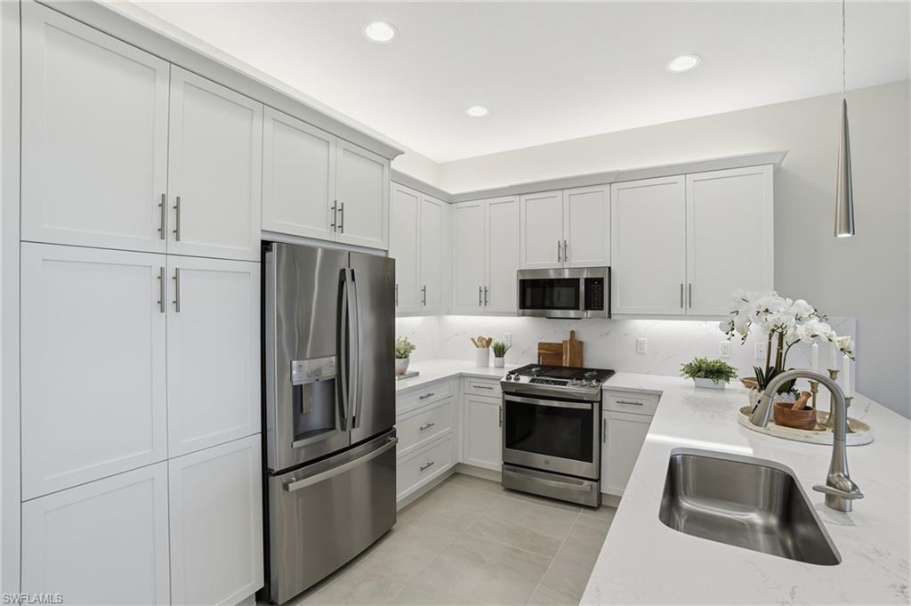 12391 Purple Ficus Way Naples, FL 34120 - Photo 11 of 47 a kitchen with granite countertop a refrigerator and a sink