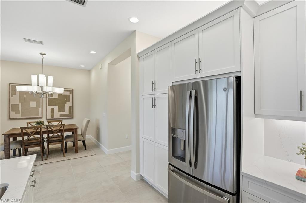 12391 Purple Ficus Way Naples, FL 34120 - Photo 12 of 47 a kitchen with stainless steel appliances a refrigerator and cabinets