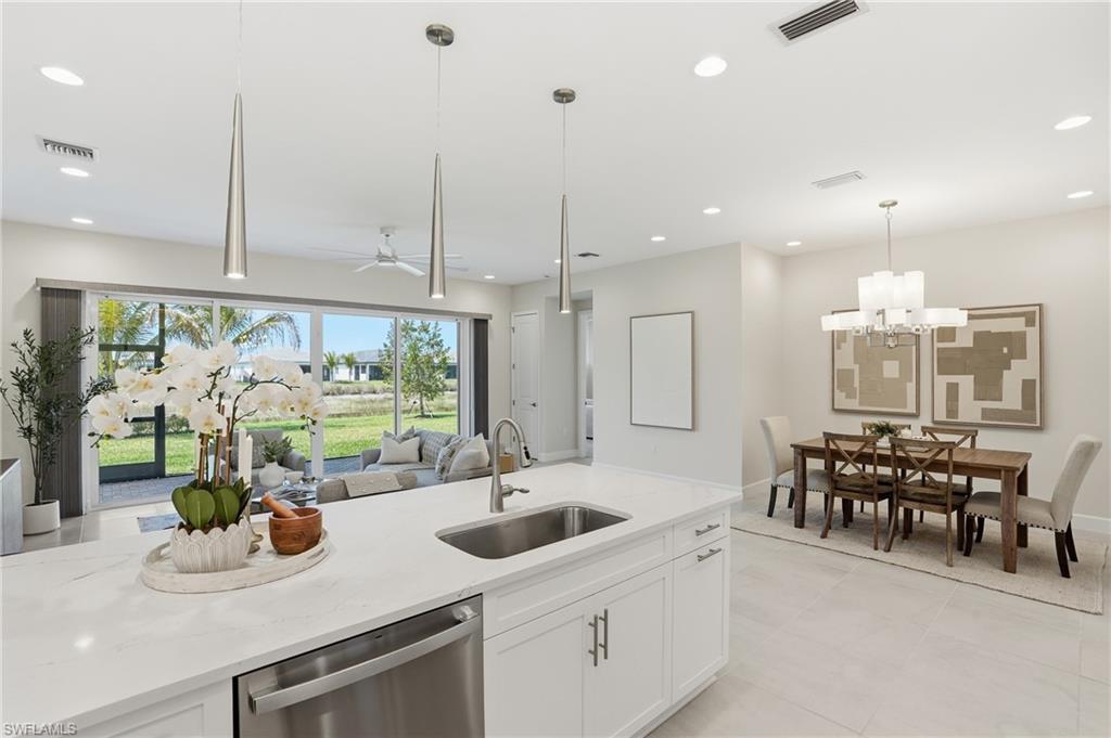 12391 Purple Ficus Way Naples, FL 34120 - Photo 13 of 47 a kitchen with stainless steel appliances kitchen island granite countertop a sink and cabinets