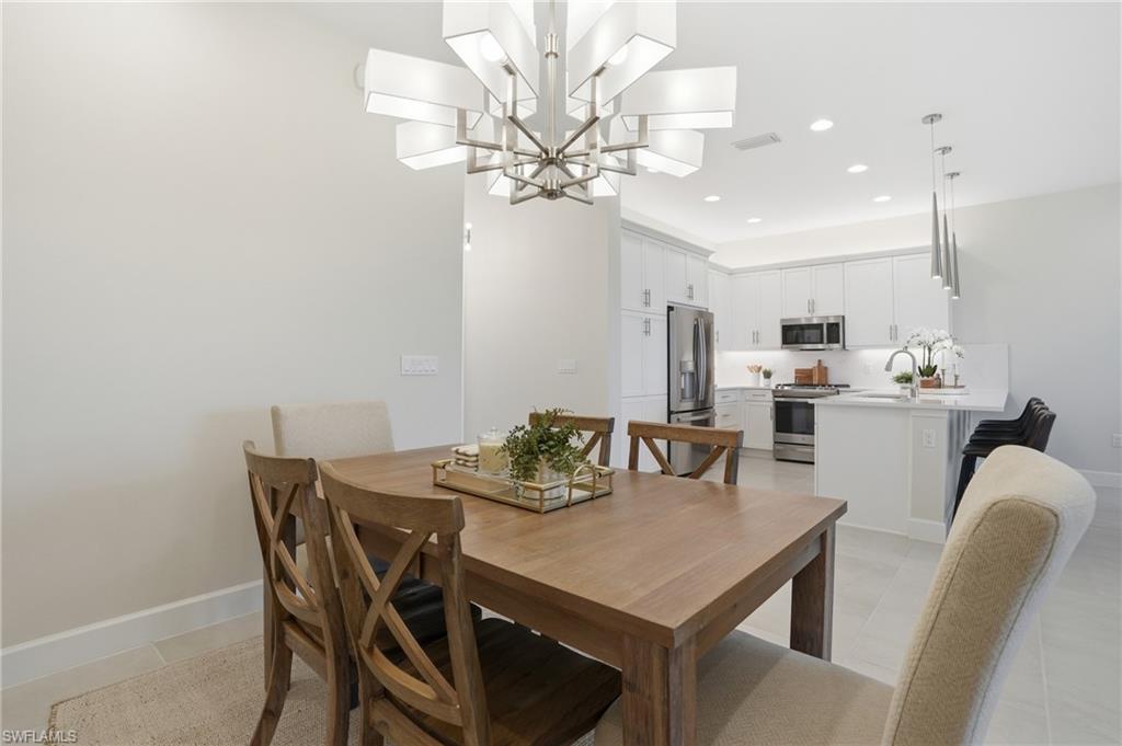 12391 Purple Ficus Way Naples, FL 34120 - Photo 20 of 47 a view of a dining room with furniture and a chandelier fan