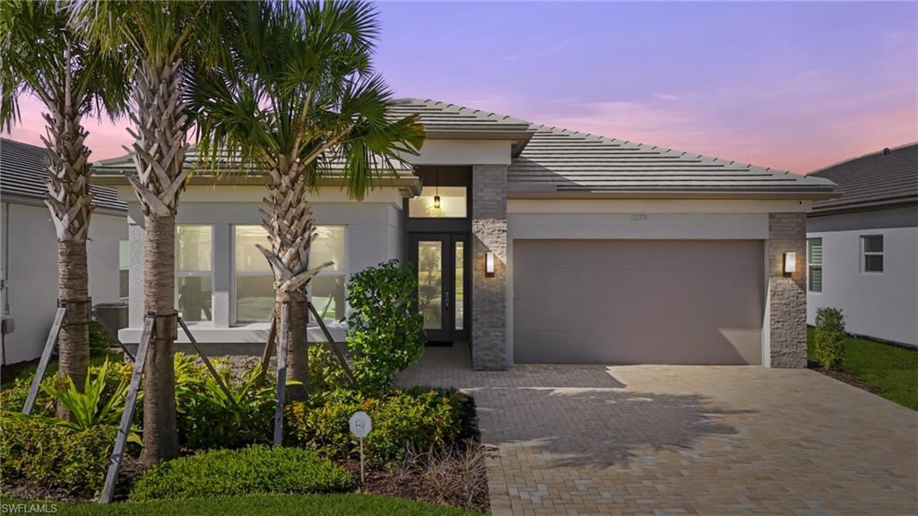 12391 Purple Ficus Way Naples, FL 34120 - Photo 2 of 47 a front view of a house with a yard