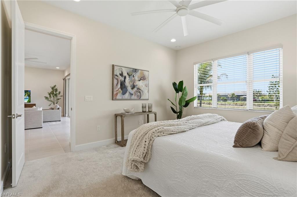 12391 Purple Ficus Way Naples, FL 34120 - Photo 24 of 47 a bedroom with a large bed and a chandelier