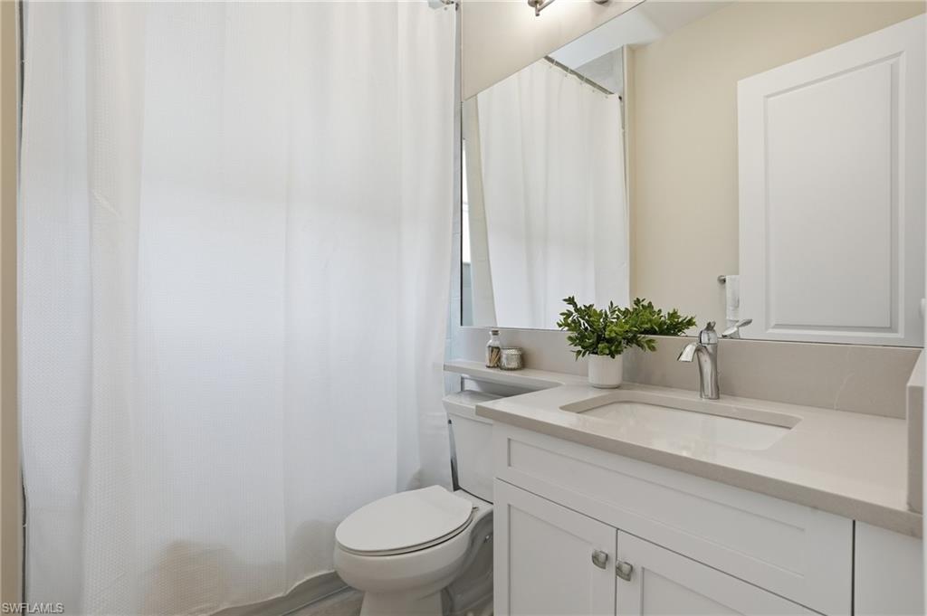 12391 Purple Ficus Way Naples, FL 34120 - Photo 30 of 47 a bathroom with a sink toilet and a mirror
