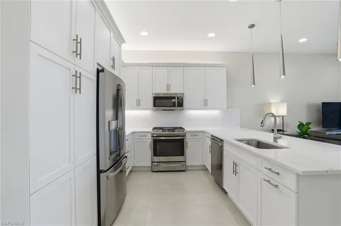 a kitchen with white cabinets and stainless steel appliances