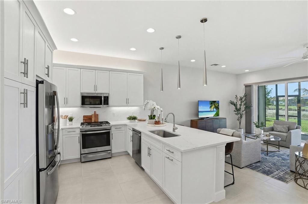 12391 Purple Ficus Way Naples, FL 34120 - Photo 10 of 47 a kitchen with a sink stainless steel appliances and counter space