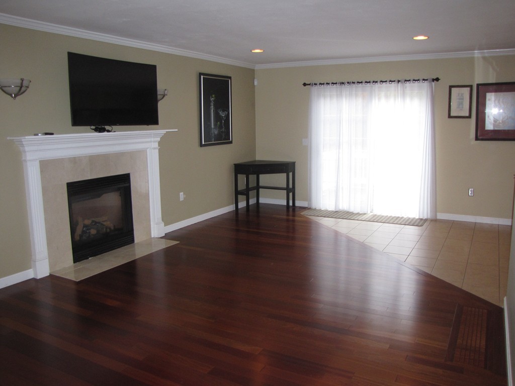 2 Erick Road Mansfield, MA 02048 - Photo 7 of 25 a view of a livingroom with furniture a fireplace and wooden floor