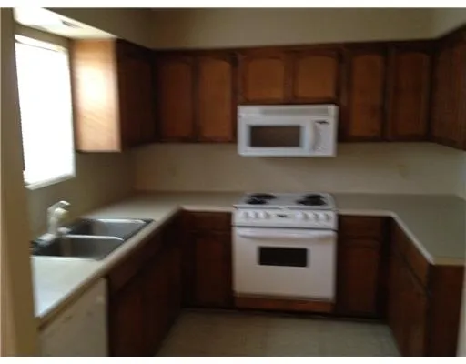 a kitchen with a stove a microwave a sink and cabinets