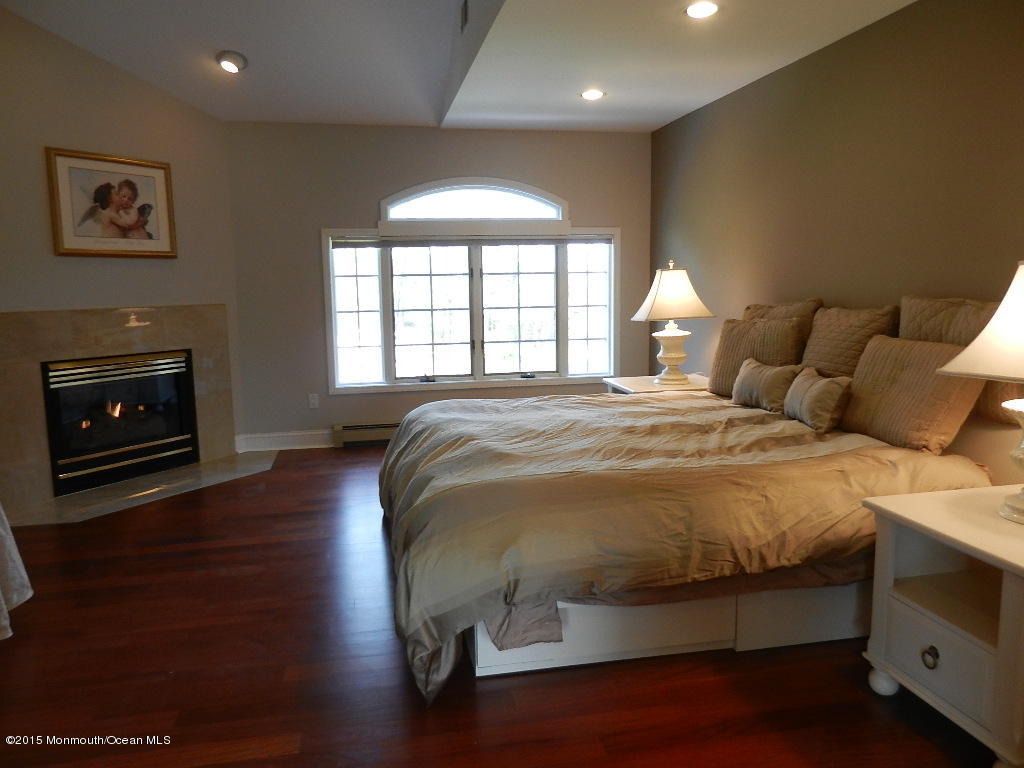 21 Statesboro Road Freehold, NJ 07728 - Photo 15 of 30 a spacious bedroom with a bed and a fireplace
