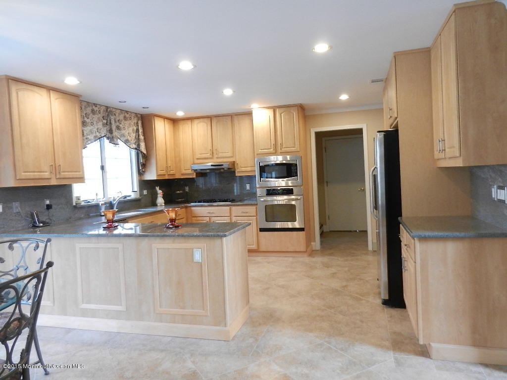 21 Statesboro Road Freehold, NJ 07728 - Photo 6 of 30 a kitchen with stainless steel appliances granite countertop a stove a sink a refrigerator and island