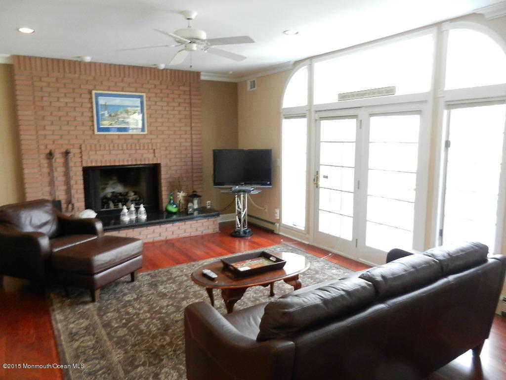 21 Statesboro Road Freehold, NJ 07728 - Photo 10 of 30 a living room with furniture a fireplace and a flat screen tv